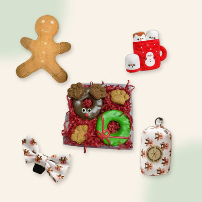 Woof Christmas Gift Box flat lay: gingerbread toy, hot chocolate toy, reindeer cookies, Ralphie Reindeer bow tie and bag holder